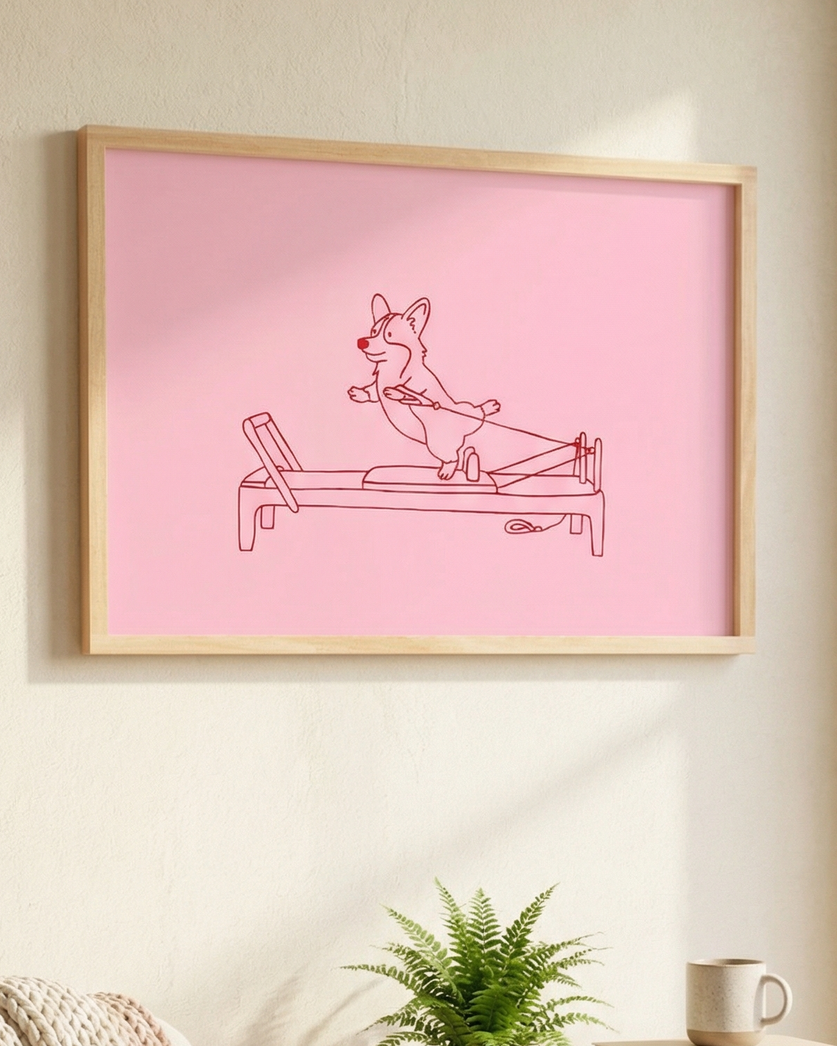 Framed pink poster with a corgi dog doing mega reformer pilates