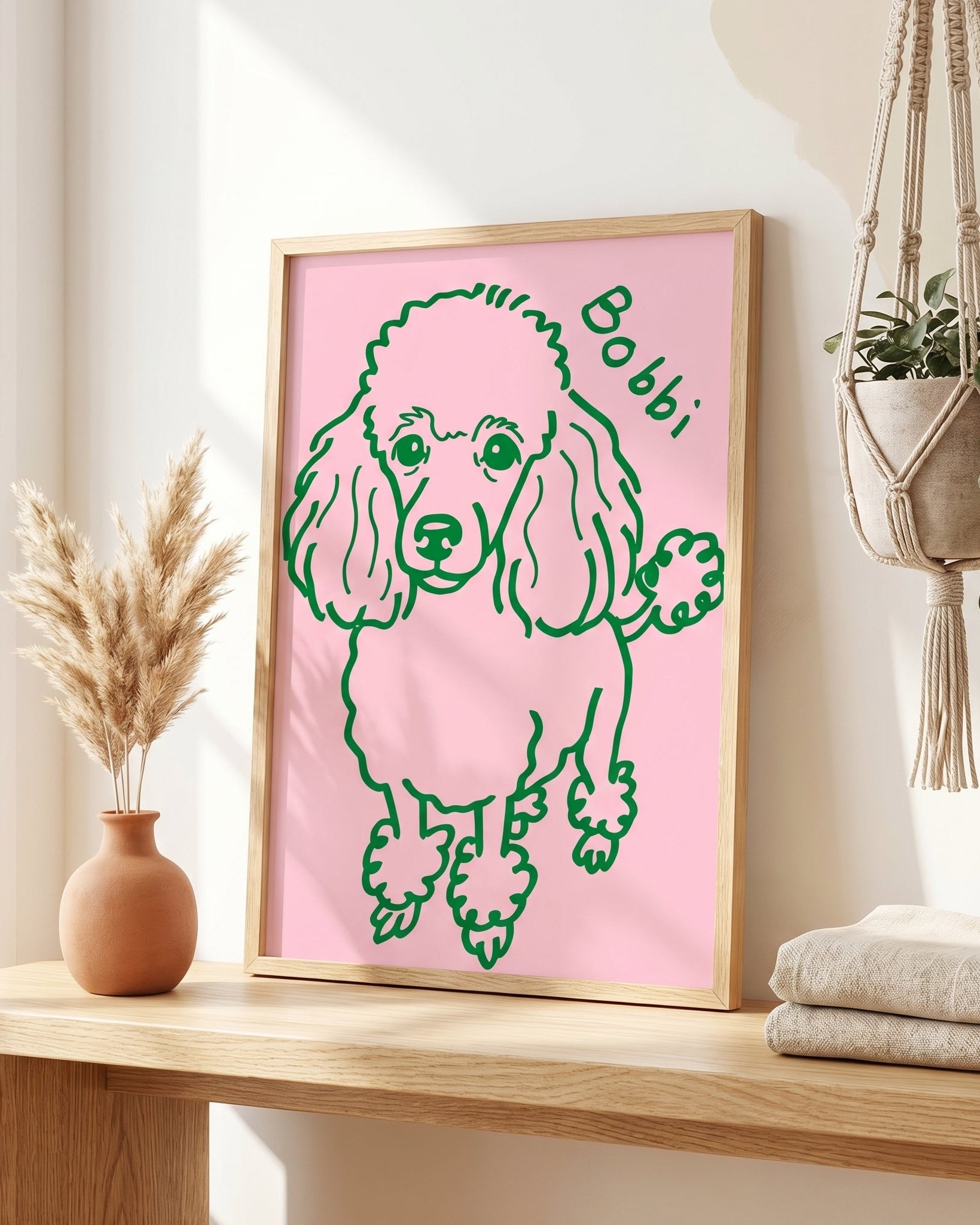 Framed illustration of a poodle on a pink background, sitting on a wooden surface.